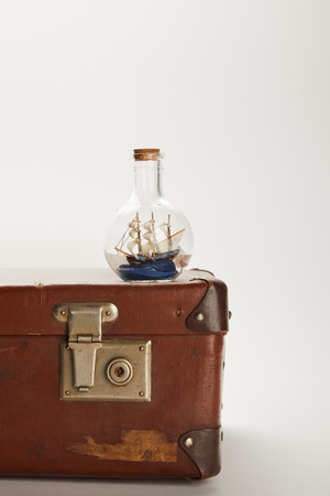 toy ship in glass bottle on brown suitcase with copy spaceの写真素材