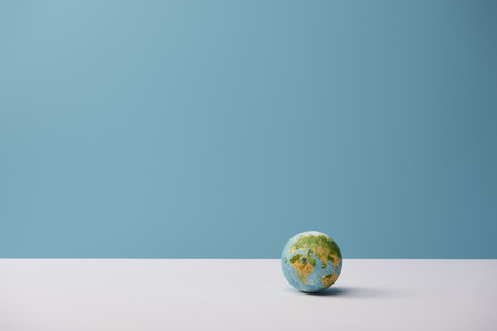 small globe on white table and blue backgroundの写真素材