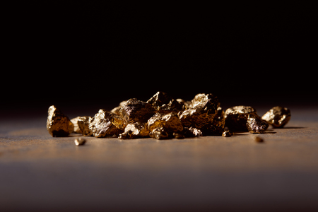 unwrought golden stones at dark on marble table and black backgroundの写真素材