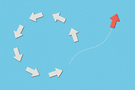 top view of red pointer and white arrows in circle on blue marked backgroundの写真素材