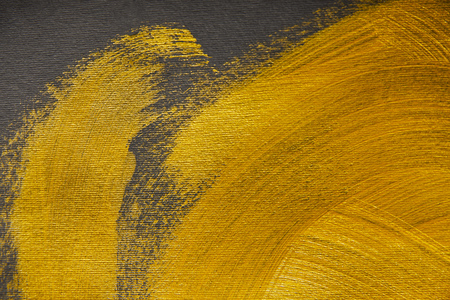 golden brushstrokes drawn on grey textured backgroundの写真素材