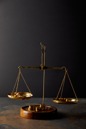 vintage scales with golden stones on marble surface and black backgroundの写真素材