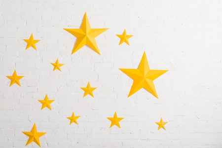 Yellow cardboard stars on light textured backgroundの写真素材