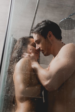 selective focus of naked man and beautiful woman hugging and taking showerの素材 [FY310119078784]