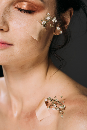 beautiful woman with closed eyes and flowers on body isolated on greyの写真素材