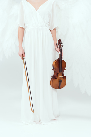 cropped view of woman in angel costume with wings holding violin and bow isolated on whiteの写真素材