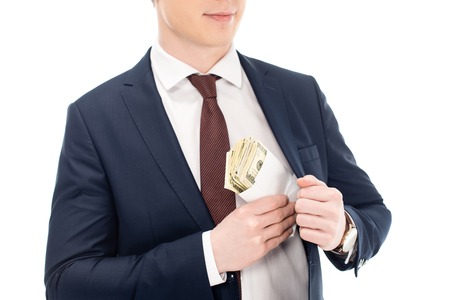 cropped view of businessman putting bribe into pocket isolated on white