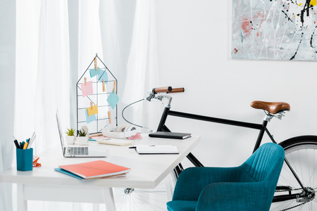 Cozy home office with modern furniture and black bicycleの写真素材