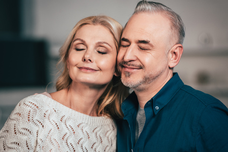 happy wife and husband smiling with closed eyes at home