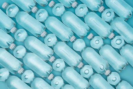 pattern with plastic water bottles isolated on turquoiseの写真素材