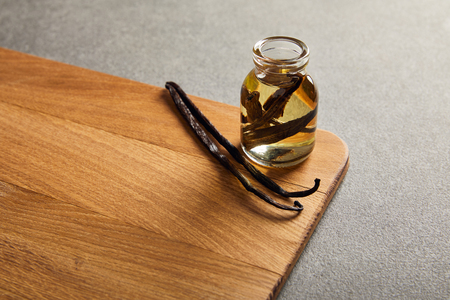 Vanilla pods and bottle with essential oil on wooden surfaceの写真素材
