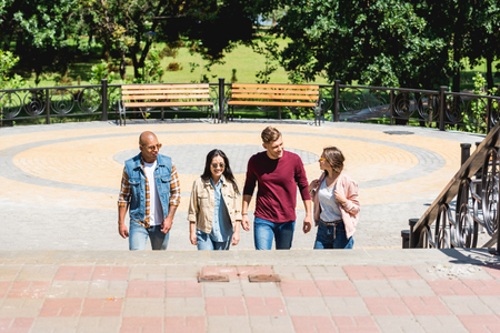 multicultural group of friends smiling in parkの写真素材