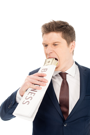 young businessman biting dollar banknotes wrapped in business newspaper, isolated on whiteの写真素材
