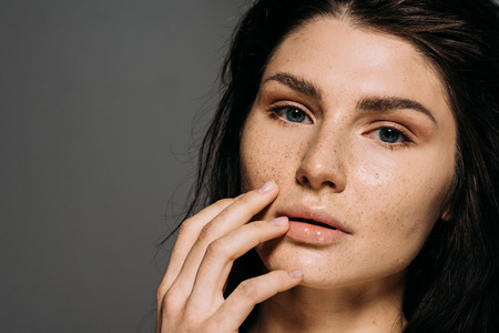 attractive tender girl with freckles on face isolated on greyの写真素材