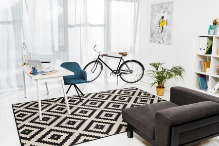 Home office with furniture and green plant in pot