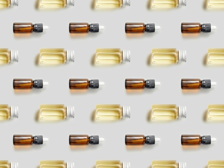 Flat lay with glass bottles of essential oil on grey backgroundの写真素材