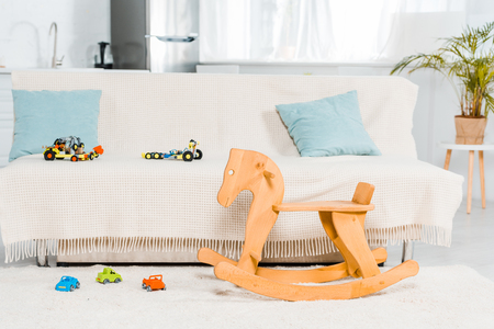 modern interior design of living room with couch, car toys and wooden rocking horseの写真素材