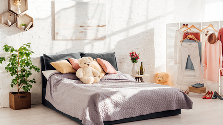 modern interior design of bedroom with teddy bear toys, pillows, plants and bedの写真素材