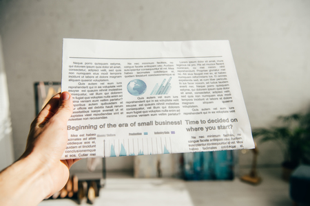 cropped view of man holding business newspaper in handの写真素材