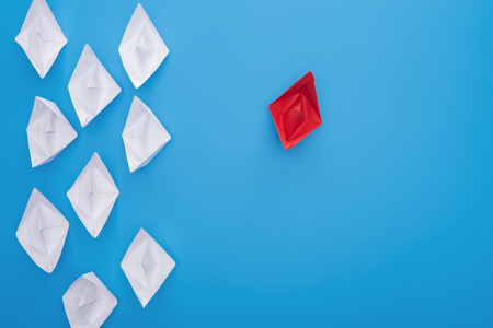 Flat lay with white and red paper boats on blue surfaceの写真素材