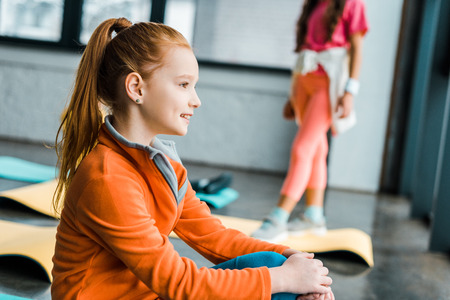 Dreamy ginger kid with pony tail posing in gymの写真素材