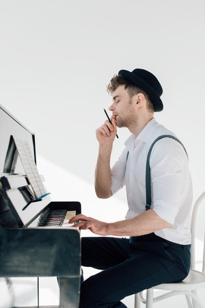handsome man composing music while sitting at piano