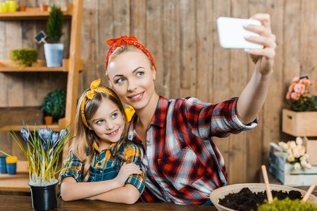 selective focus of beautiful mother taking selfie with cute daughterの写真素材