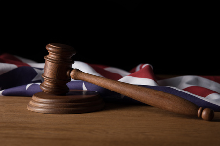 wooden gavel and american flag on table isolated on blackの写真素材