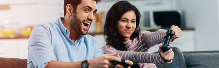 happy latin man playing video game with wife at home