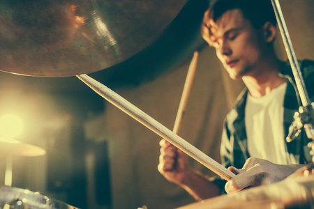 selective focus of drum sticks in hands of young drummerの写真素材