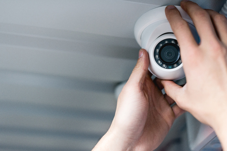cropped view of man setting up security cameraの写真素材