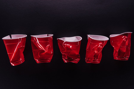 Red plastic cups isolated on a black backgroundの写真素材