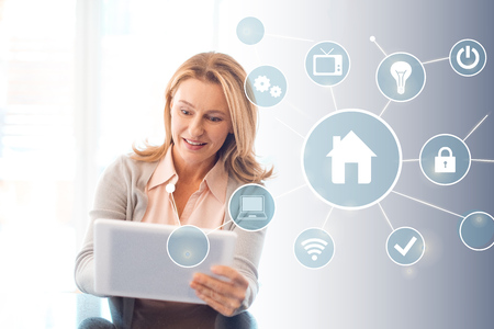 pretty blonde woman using digital tablet, smart home conceptの写真素材