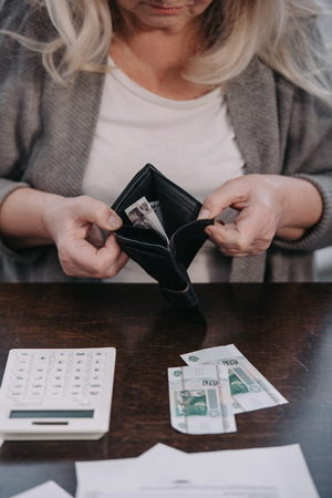 cropped view of senior woman holding wallet with moneyの写真素材