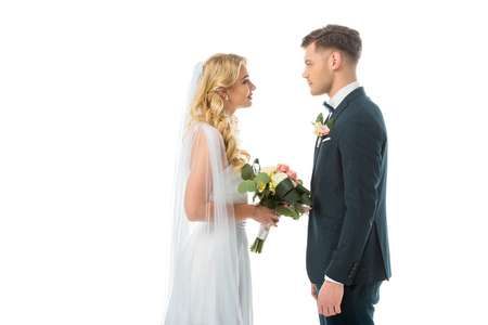 happy bride and smiling groom looking at each other isolated on whiteの写真素材