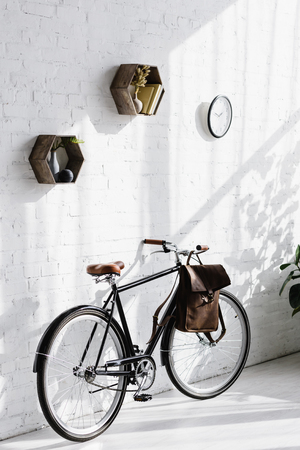 black bicycle with bag near white brick wall in officeの写真素材