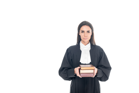 Serious judge in judicial robe holding books isolated on whiteの写真素材