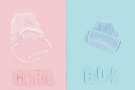 top view of bonnet and hat, boy or girl lettering on pink and blue backgroundの写真素材