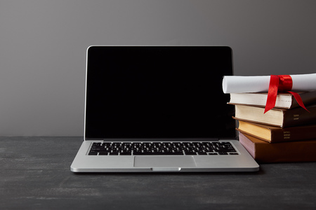 Laptop with blank screen, diploma and books isolated on greyの写真素材