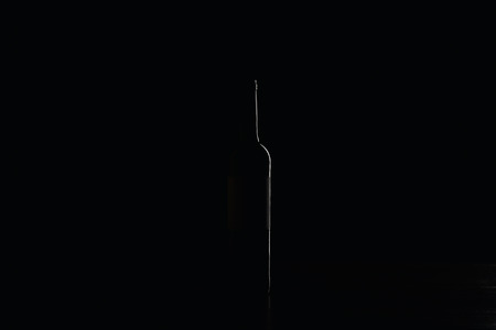Wine bottle on dark suface isolated on blackの写真素材