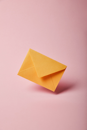yellow and colorful envelope on pink background with copy spaceの写真素材
