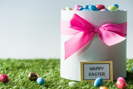 gift box with pink bow full of multicolored Easter eggs isolated on white