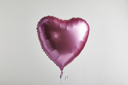 heart-shaped pink balloon isolated on whiteの写真素材