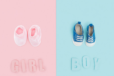 top view of boy and girl lettering and sneakers, booties on pink and blue backgroundの写真素材