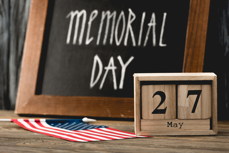 wooden cubes with date near flag of america with stars and stripes and memorial day lettering on chalkboardの写真素材