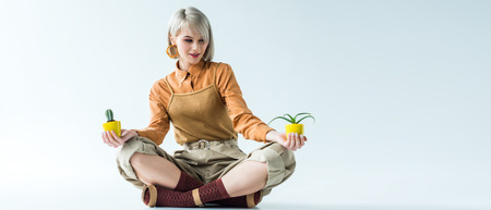 panoramic shot of beautiful stylish girl with flower pots isolated on white with copy spaceの写真素材