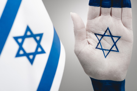 selective focus of female hand with star of david near flag on greyの写真素材