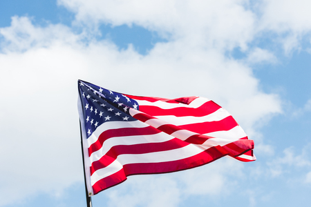 low angle view of flag with stars and stripes against blue skyの写真素材