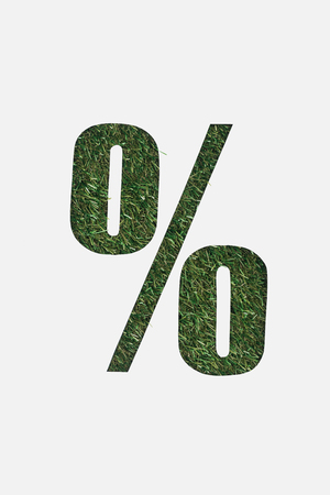 top view of cut out percent sign on green grass background isolated on whiteの写真素材