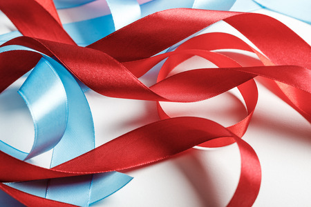 curved blue and red satin ribbons on grey backgroundの写真素材